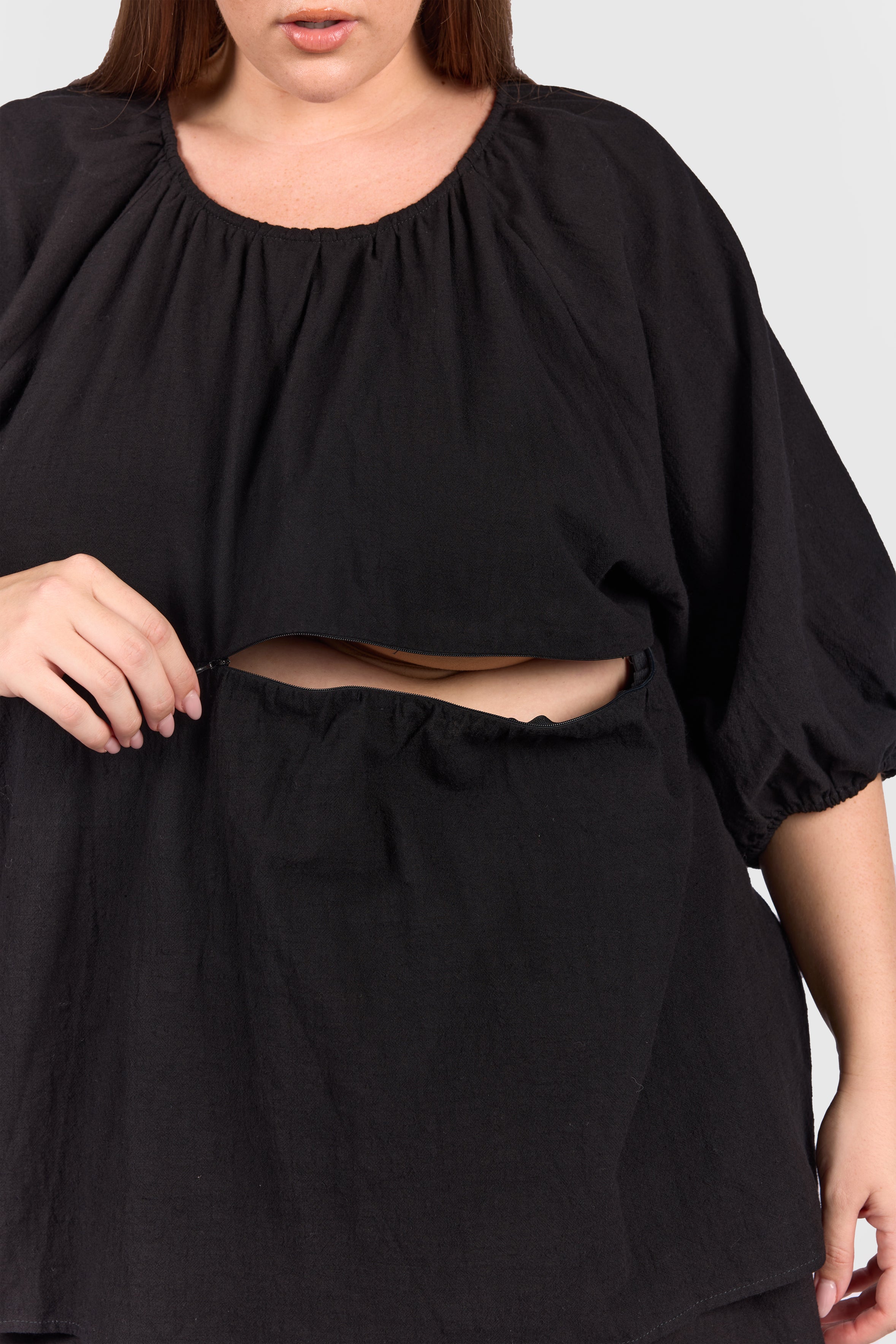 Close up of black peplum top with hidden breastfeeding zip.