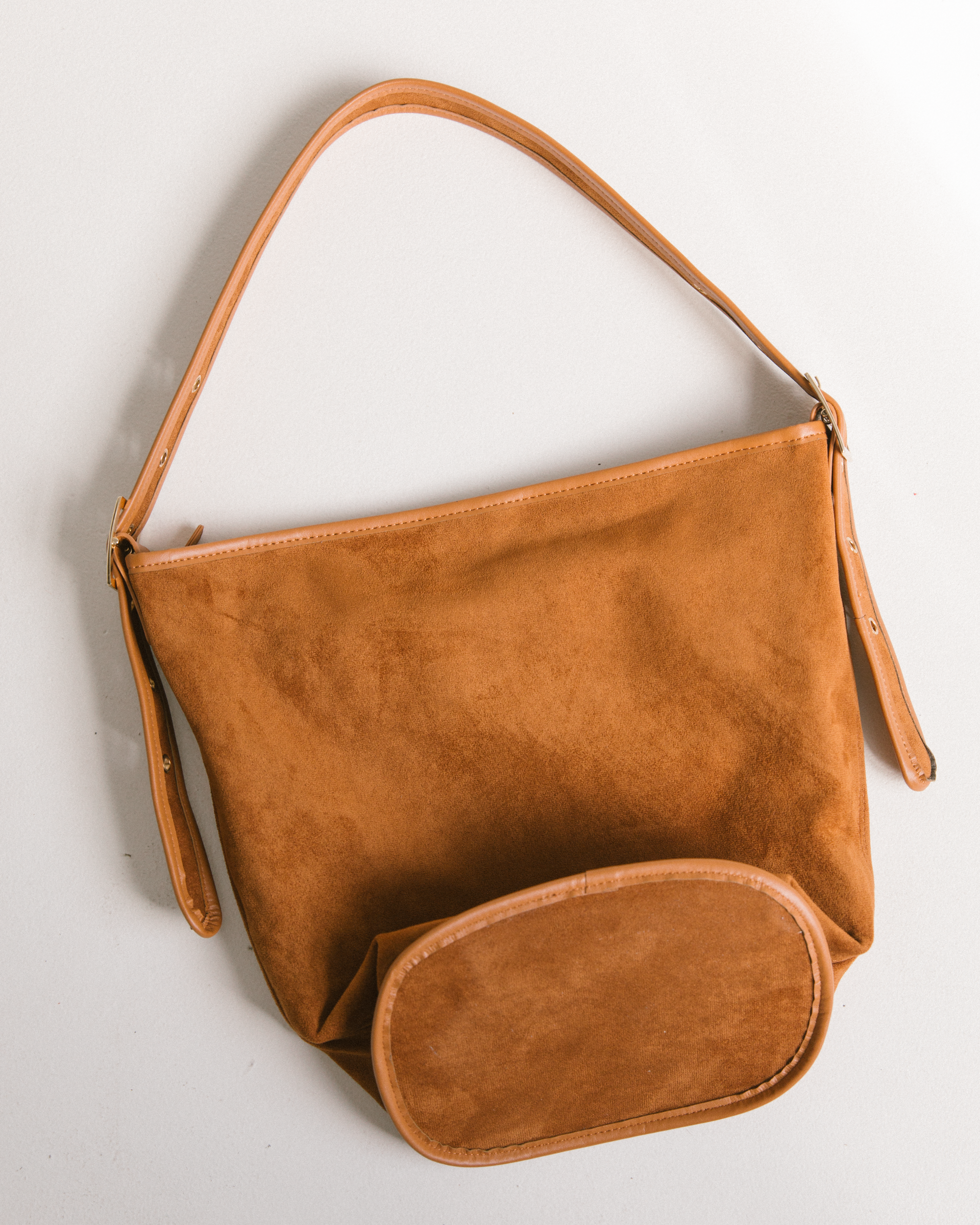 Close up of tan suede-look handbag with adjustable straps.