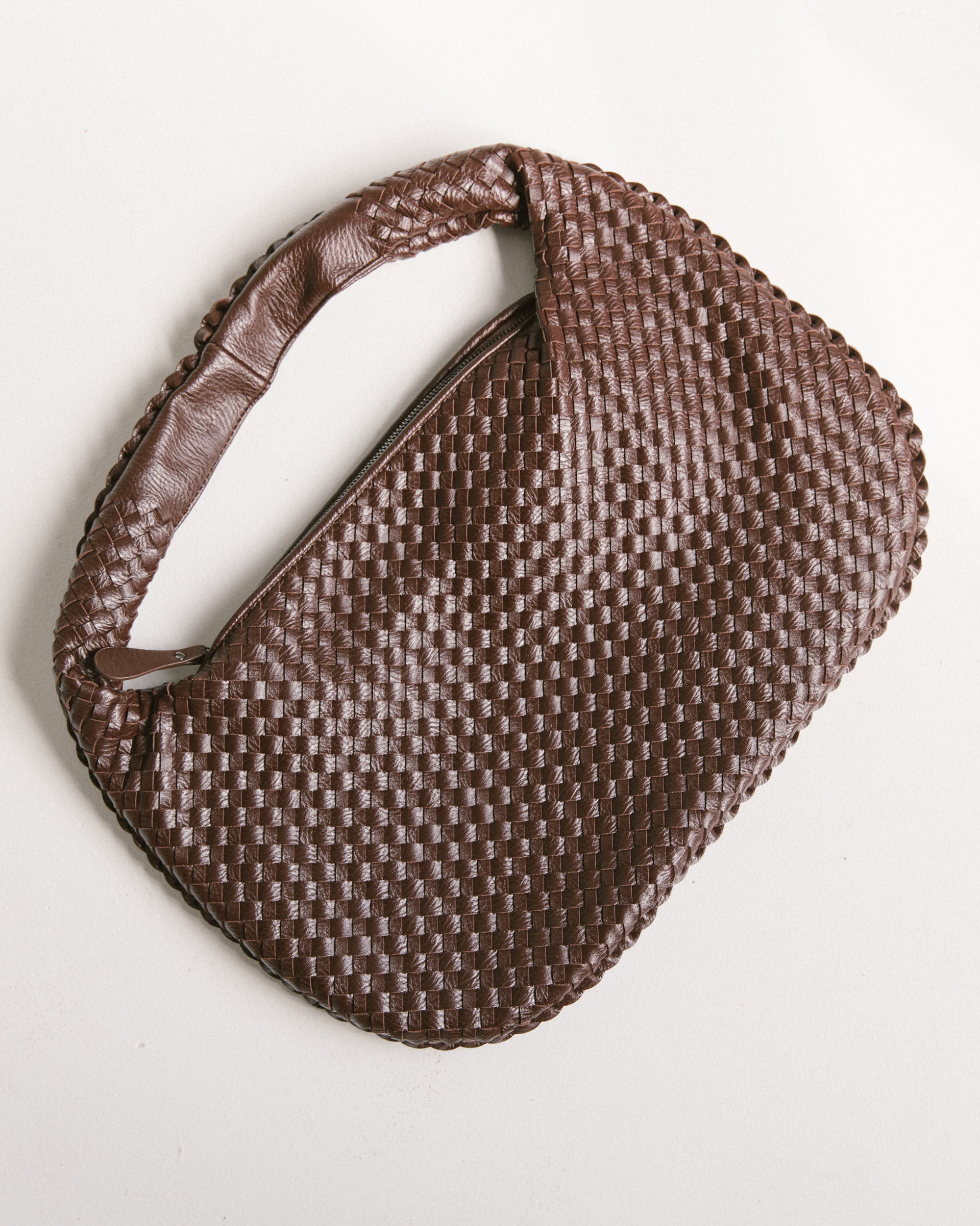 Close up of brown leather-look brown woven handbag.