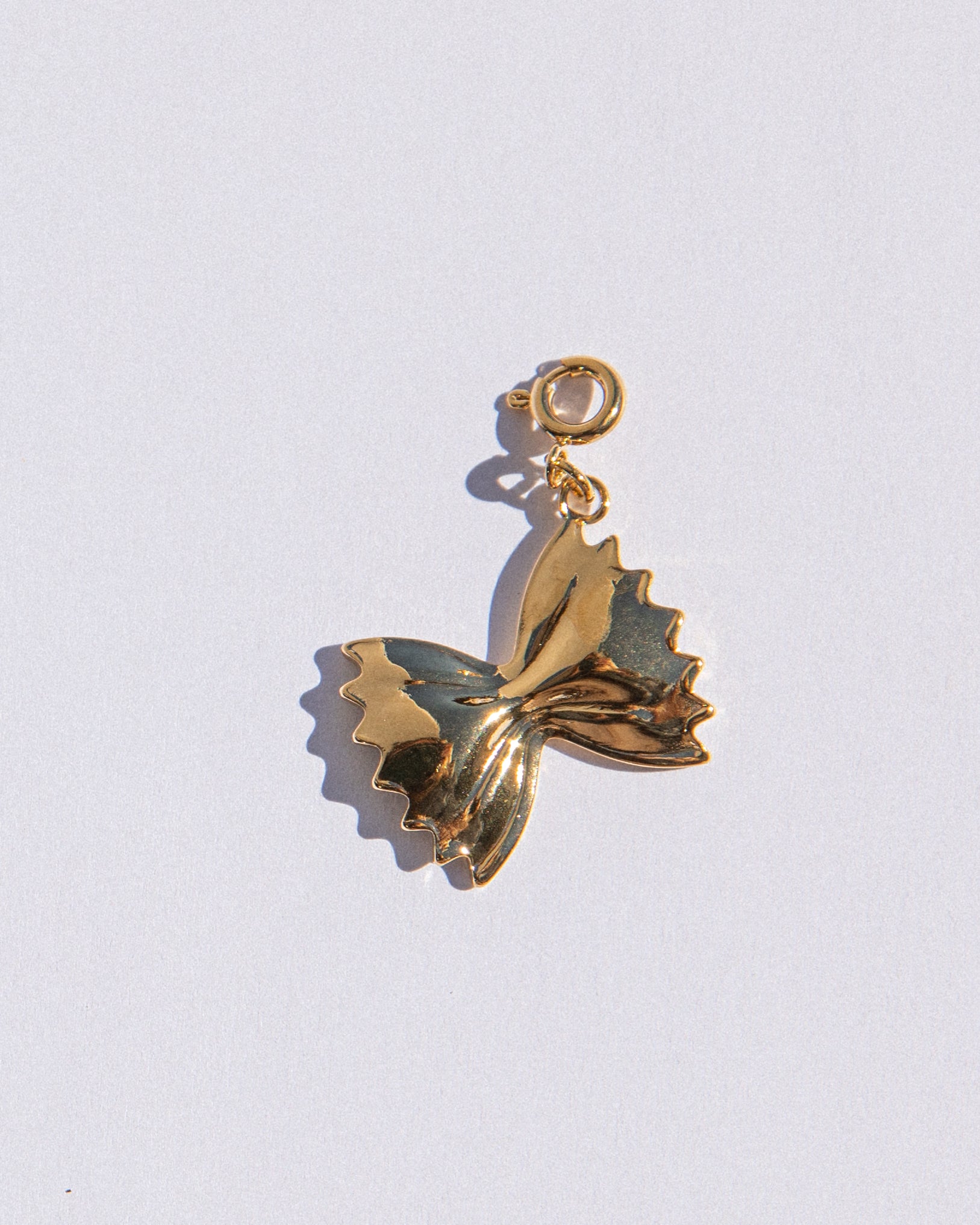 Gold butterfly pendant on a white background
