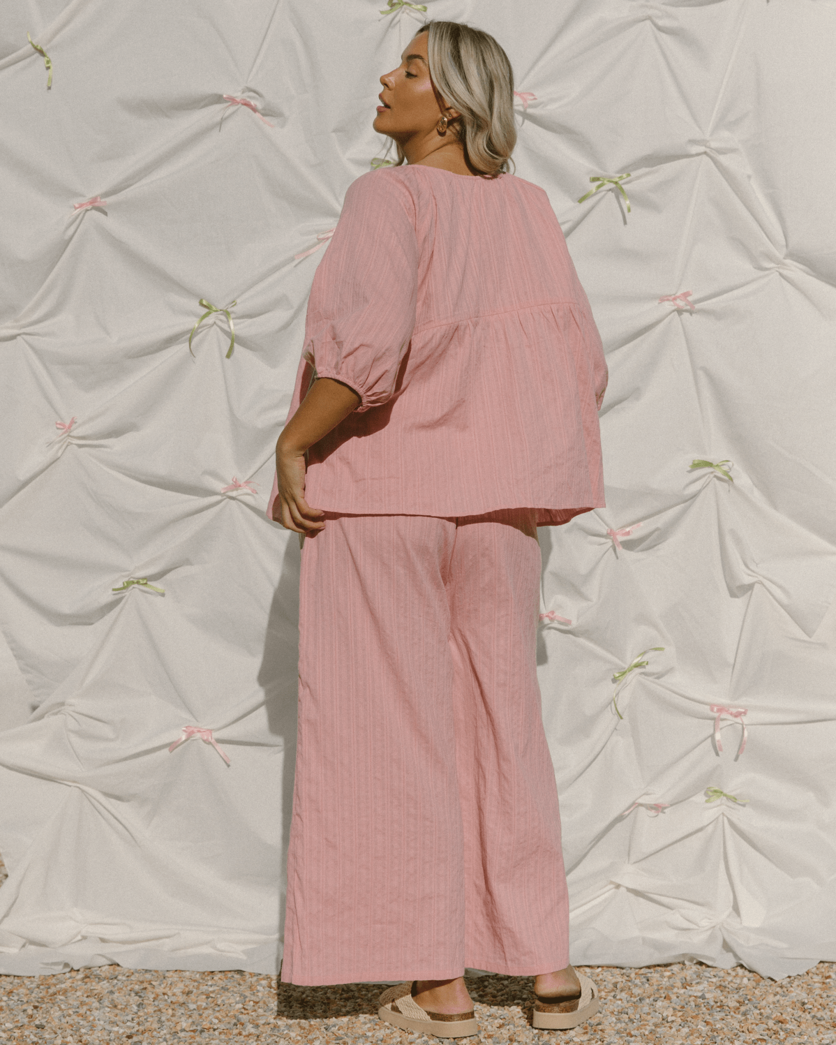 Woman wearing a trendy, oversized pink co-ord set.