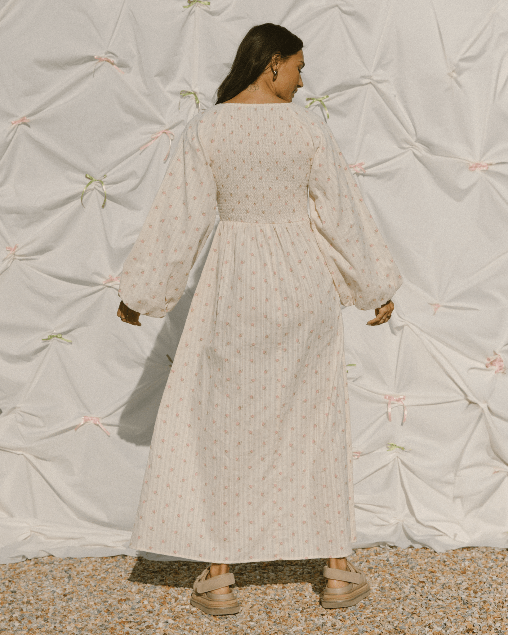 Woman wearing delicate pink flower maxi dress with a shirred bust.