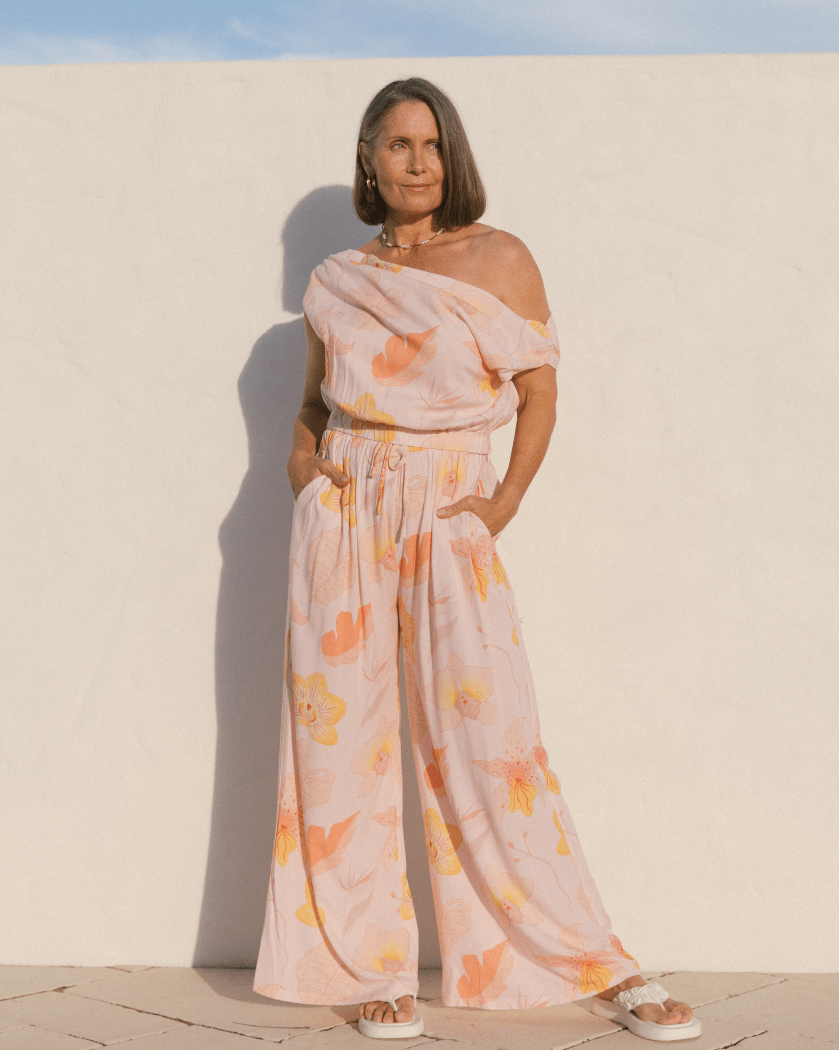 Woman wearing a stylish spring outfit in a light pink floral design.