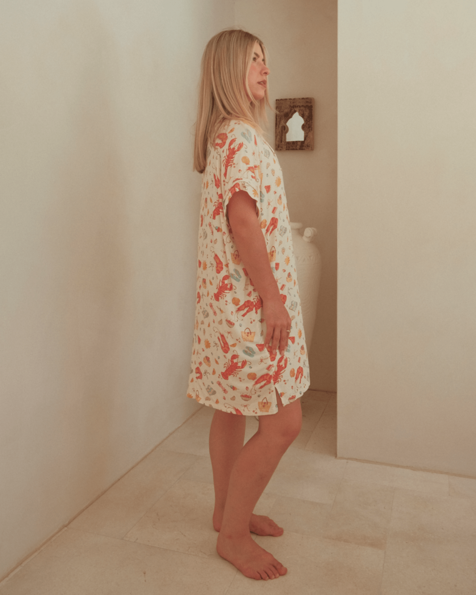 Woman wearing a pattern nightgown that features short sleeve & oversized fit.