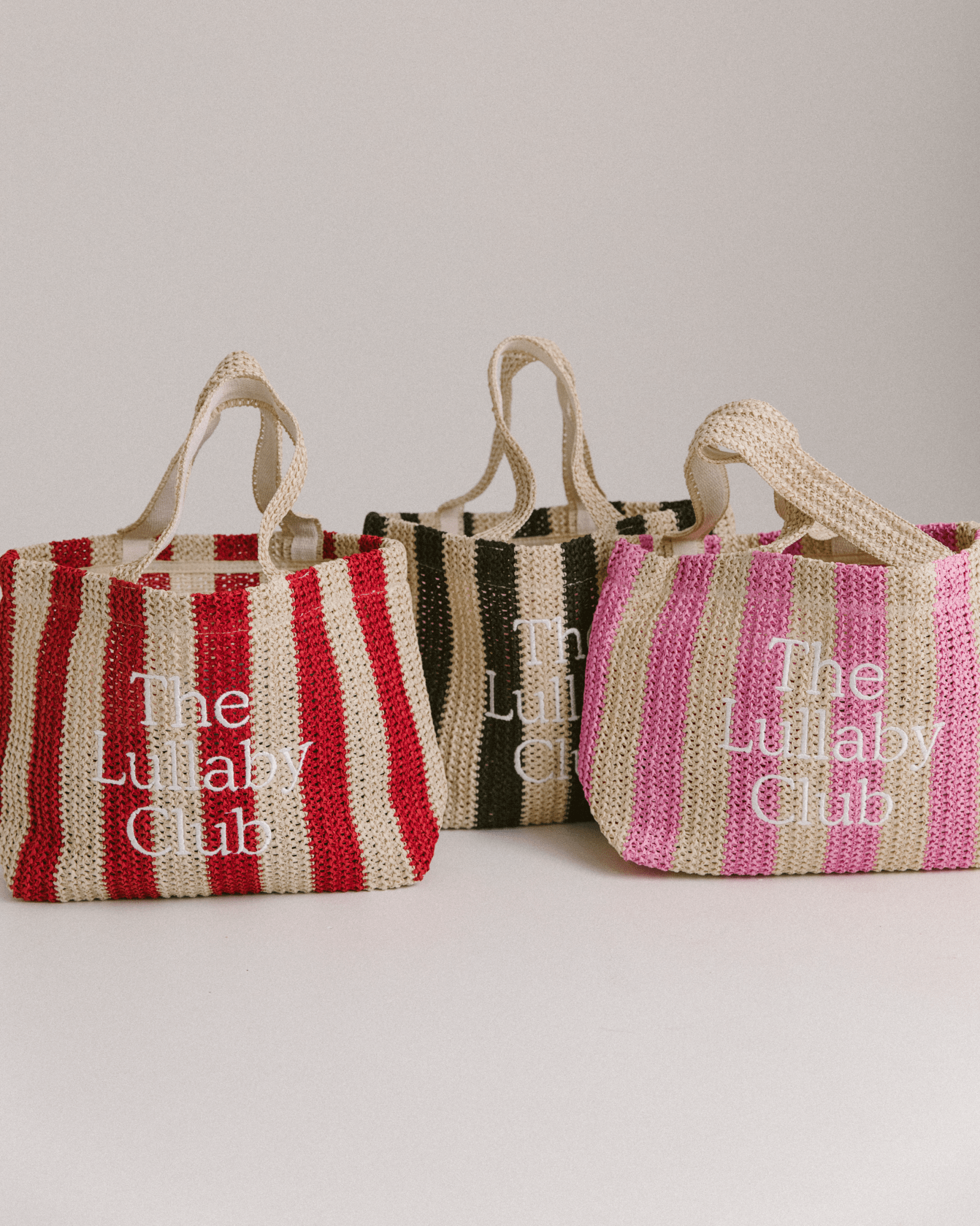 3 holiday style tote bags made from woven material in different coloured striped patterns.