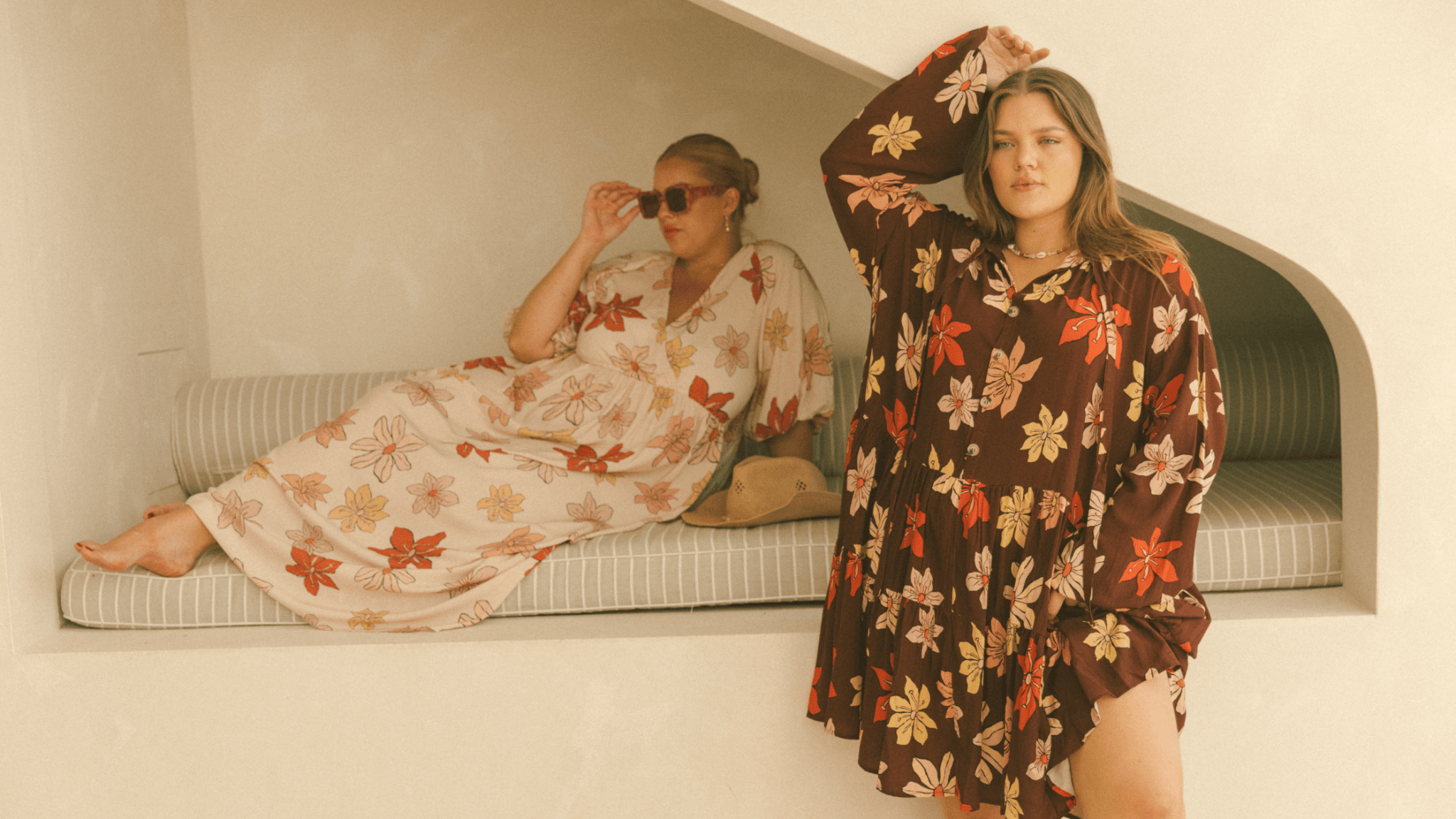 Effortless autumn outfits featuring The Lullaby Club's Desert Sun collection. Two women in chic floral maxi dresses with warm-toned prints, perfect for seasonal style. Soft, flowy silhouettes designed for comfort and versatility, ideal for maternity, post