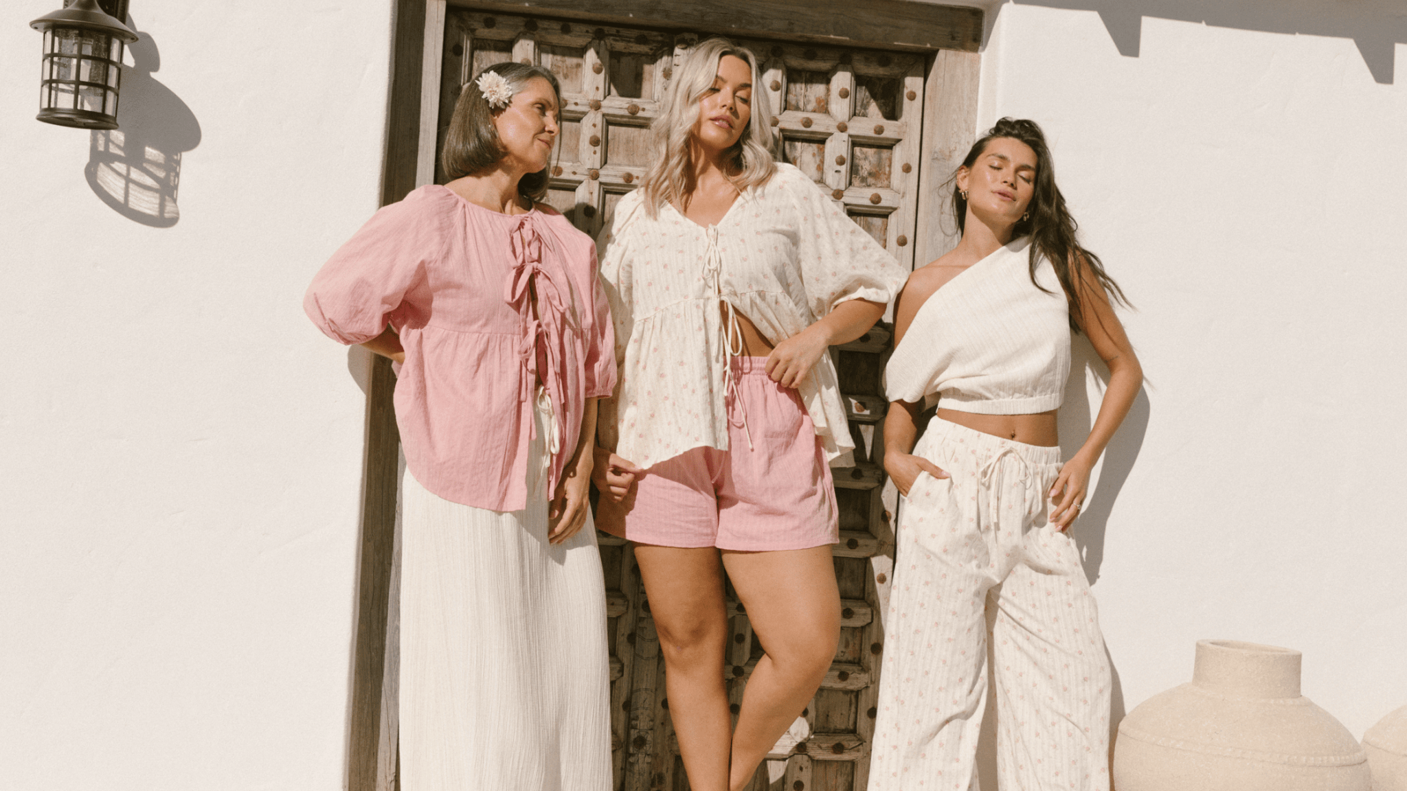 Three women wearing linen printed sets, relaxed sitting on stairs outside in a fashionable manner