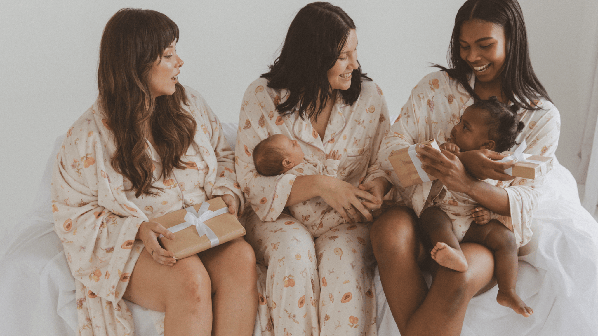 three mothers holding babies in the lullaby club x little and fern exclusive pyjams cozy comfy breastfeeding friendly mothers day gifts