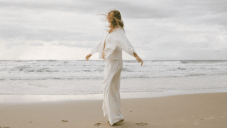 a pregnant woman in lounge wear on the beach 