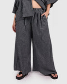 Woman wearing a black and white checkered outfit on a white background