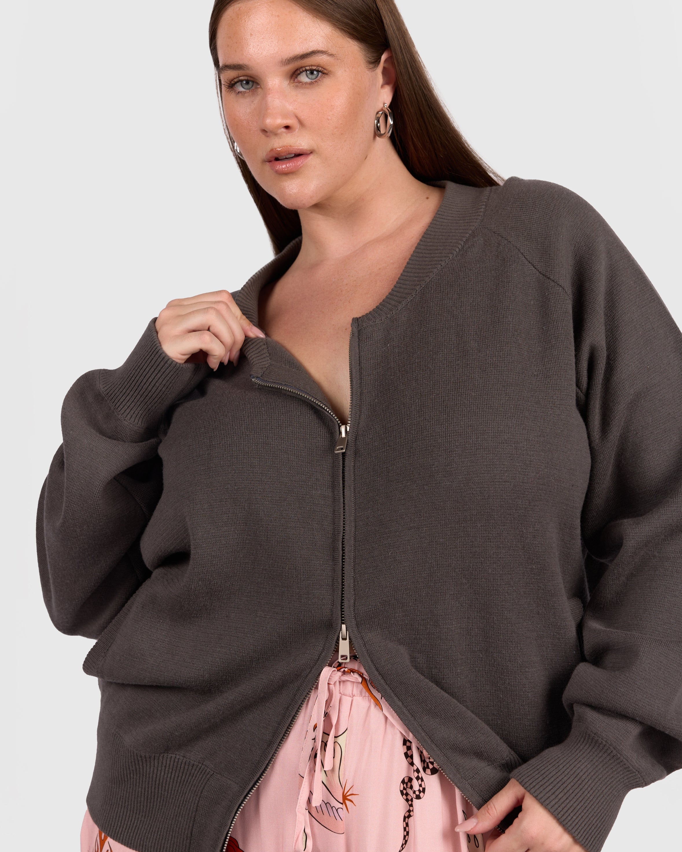 Woman wearing knit bomber in charcoal colour with two way breastfeeding access zips. 