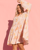 Woman wearing a floral dress against a pink background