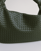 Green woven handbag on a light gray background