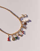 Chunky gold chain necklace with an assortment of charms attached.