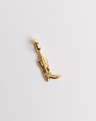 A gold-plated cowgirl boot charm against a white background.