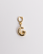 A gold-colored charm in the shape of the letter G with a secure clasp designed for attaching to necklaces or bracelets.