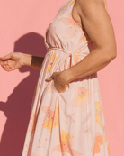Woman wearing light pink maxi dress with side seam pockets and adjustable drawstring waist