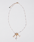 Necklace with gold and crystal elements on a light gray background