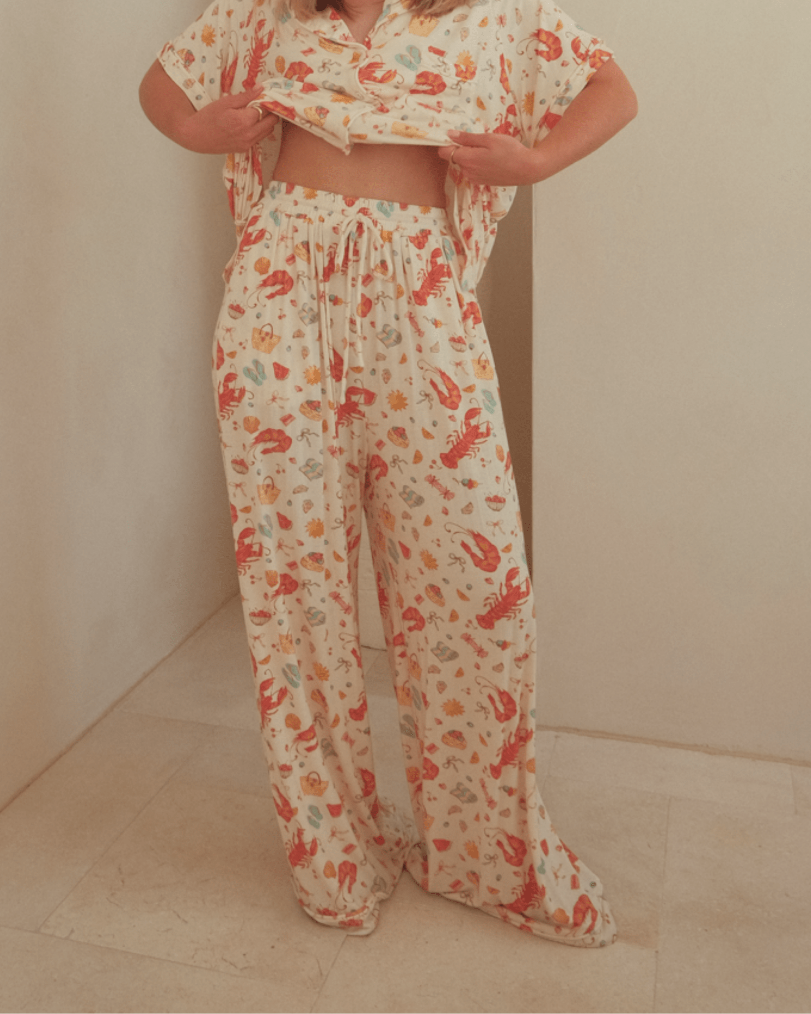 Woman wearing comfy matching loungewear in a Australian Christmas themed pattern. 