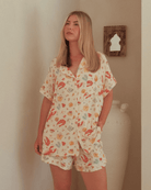 Woman wearing summer matching pyjama set that features an aussie christmas print. 