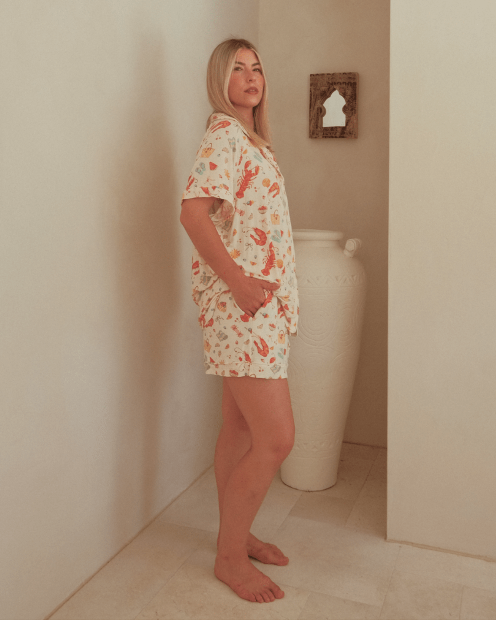 Woman wearing a pattern pj shirt & shorts. 