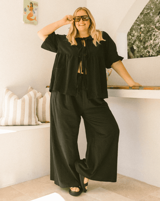 Pregnant woman wearing black maternity lounge pants - Posey Pants by The Lullaby Club