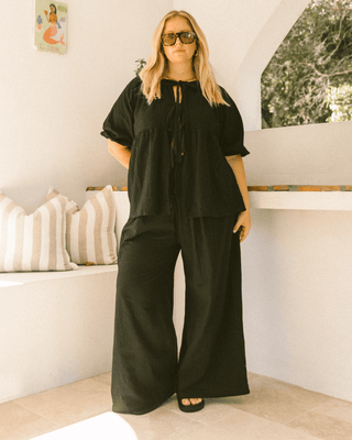 Pregnant woman wearing black maternity lounge pants - Posey Pants by The Lullaby Club