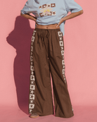 Brown floor length cotton lounge pants with adjustable elastic waistband and knit star contrast detailing down the side-seam.