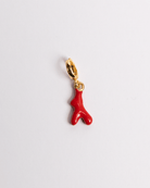 A red coral charm with a gold clasp and detailing on a white background.