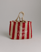 A red and natural striped raffia tote bag with 'The Lullaby Club' embroidered on it.