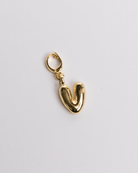 A gold-plated stainless steel charm in the shape of the letter 'V' in a bubble style. with a clasp for attaching to jewelry.